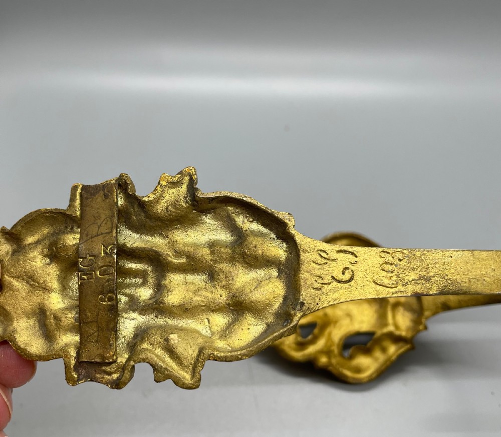 A pair of late nineteenth-century French ormolu curtain tiebacks featuring acanthus leaf scrollwork and beaded detail. View VI