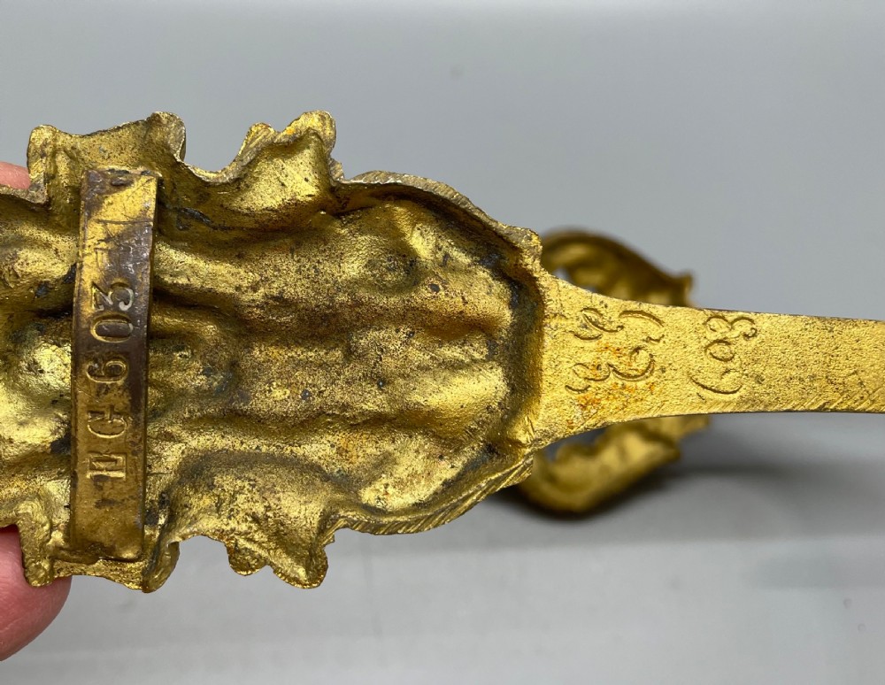 A pair of late nineteenth-century French ormolu curtain tiebacks featuring acanthus leaf scrollwork and beaded detail. View VIII