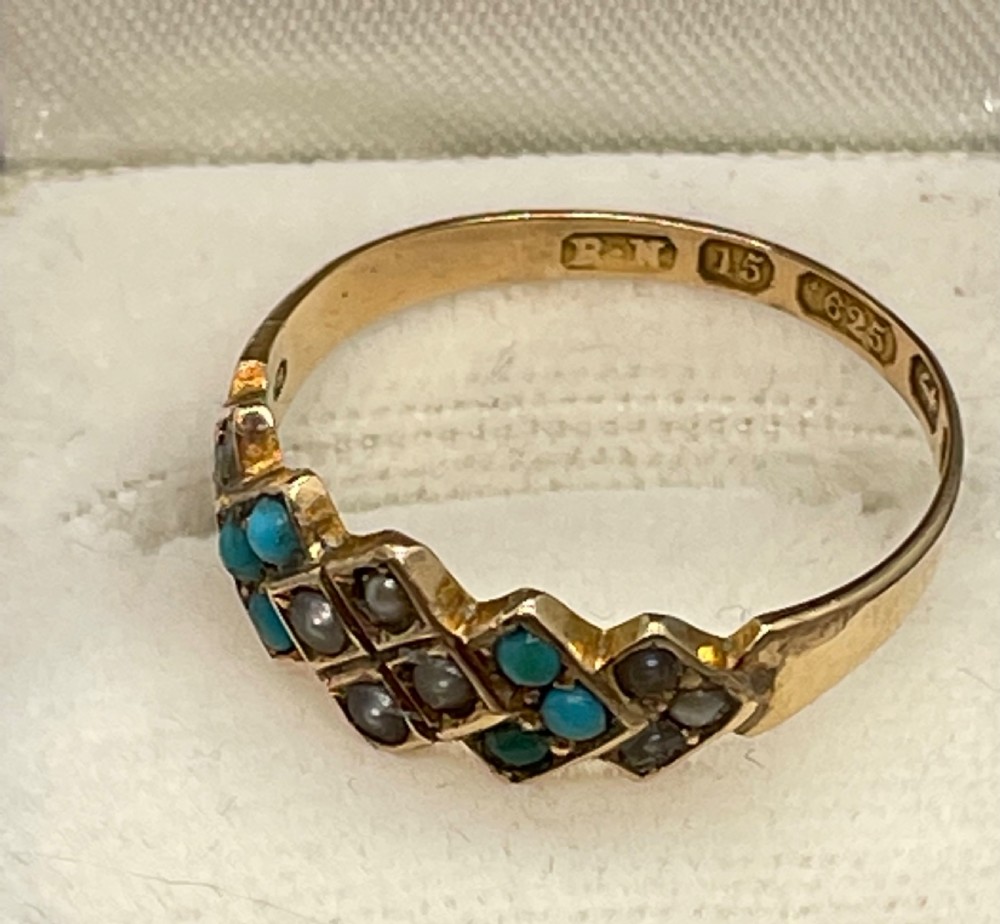A late Victorian 15ct yellow gold ring set with blue turquoise cabochons and split seed pearls in a geometric diamond setting.