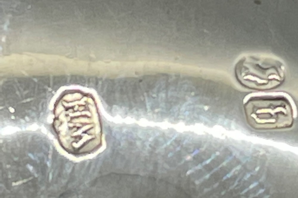A Victorian sterling silver christening mug featuring hand-engraved scrollwork and geometric patterns, supported by three spherical ball feet. View XI