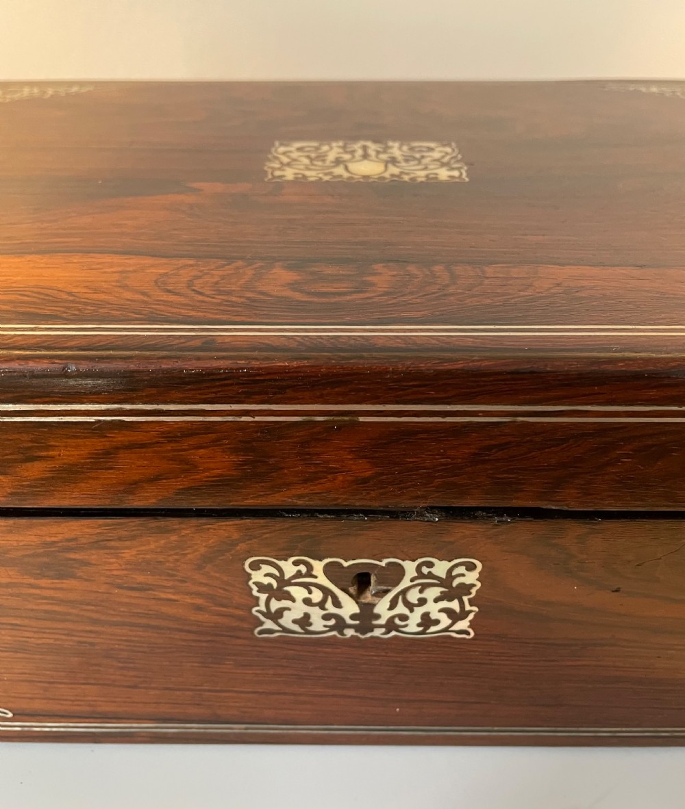 A dark brown rosewood rectangular writing slope decorated with floral mother of pearl inlay on the corners, lid centre, and lock escutcheon. View II