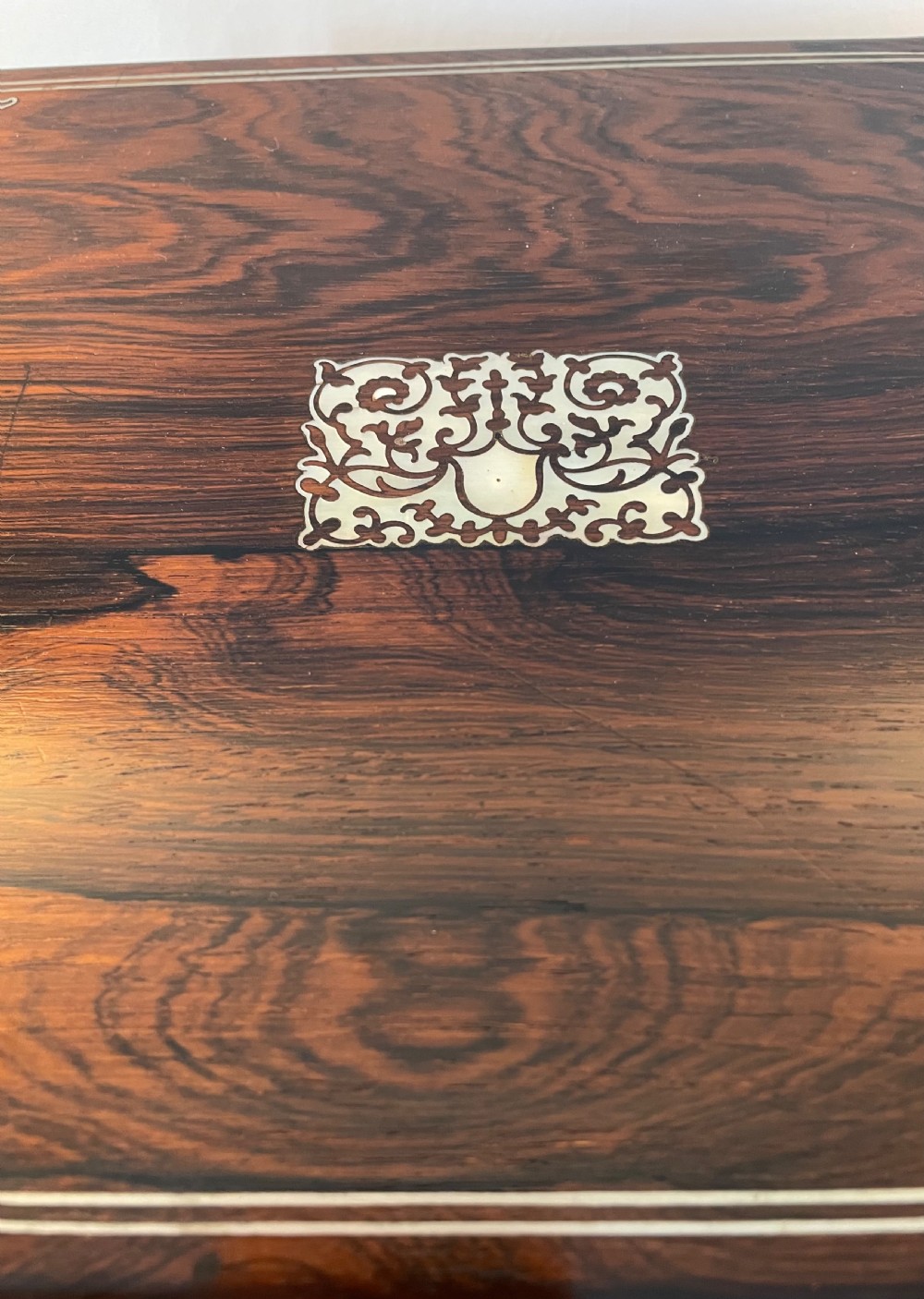 A dark brown rosewood rectangular writing slope decorated with floral mother of pearl inlay on the corners, lid centre, and lock escutcheon. View III