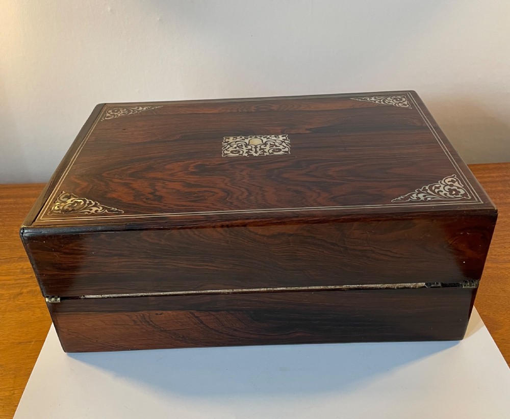 A dark brown rosewood rectangular writing slope decorated with floral mother of pearl inlay on the corners, lid centre, and lock escutcheon. View XV