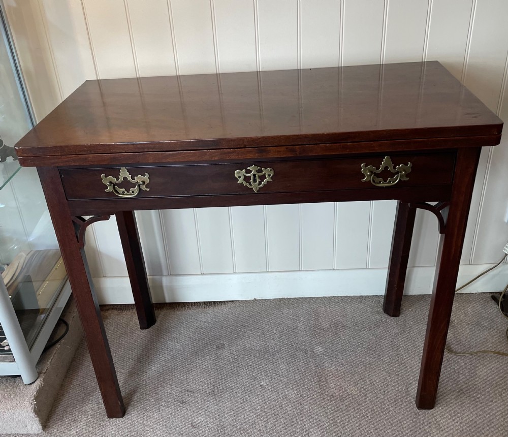 A Georgian mahogany fold-over tea table featuring straight square legs with subtle corner brackets and brass drop handles. View II