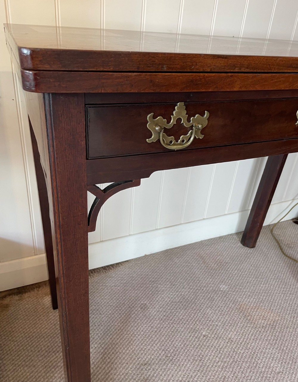 A Georgian mahogany fold-over tea table featuring straight square legs with subtle corner brackets and brass drop handles. View III