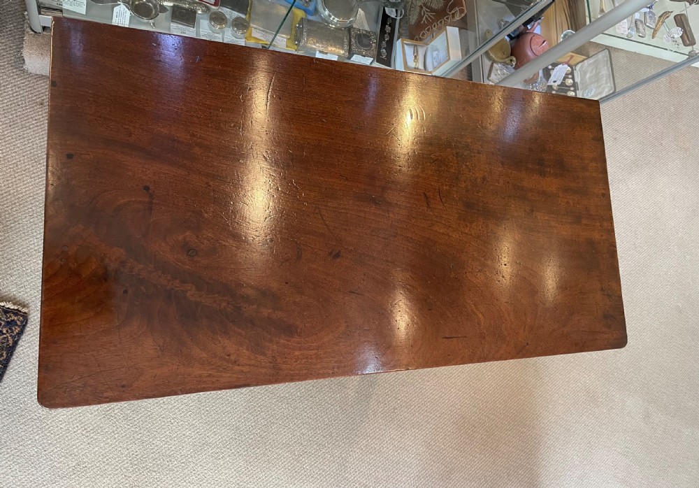 A Georgian mahogany fold-over tea table featuring straight square legs with subtle corner brackets and brass drop handles. View VI