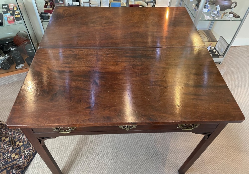 A Georgian mahogany fold-over tea table featuring straight square legs with subtle corner brackets and brass drop handles. View XI