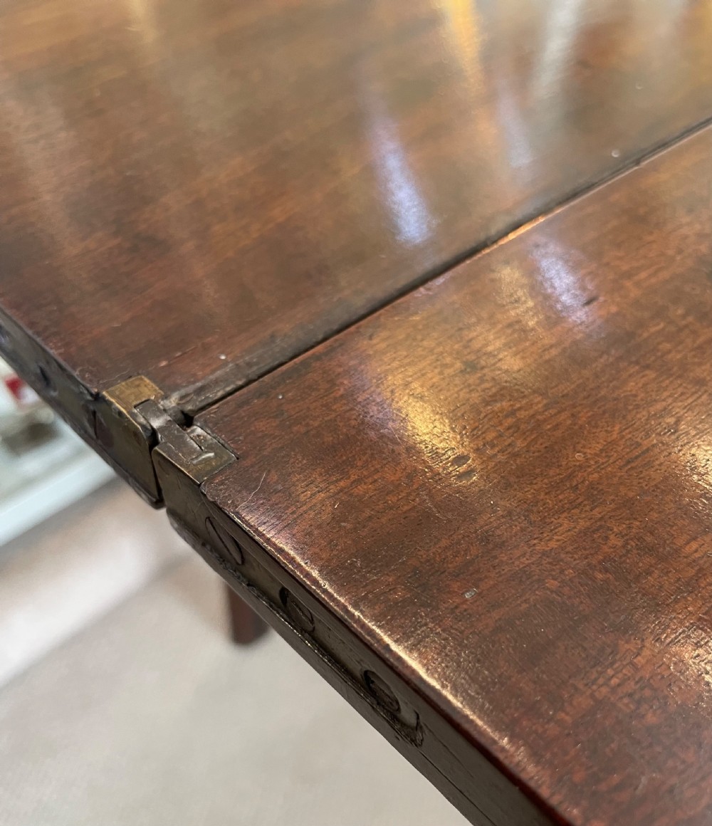 A Georgian mahogany fold-over tea table featuring straight square legs with subtle corner brackets and brass drop handles. View XII