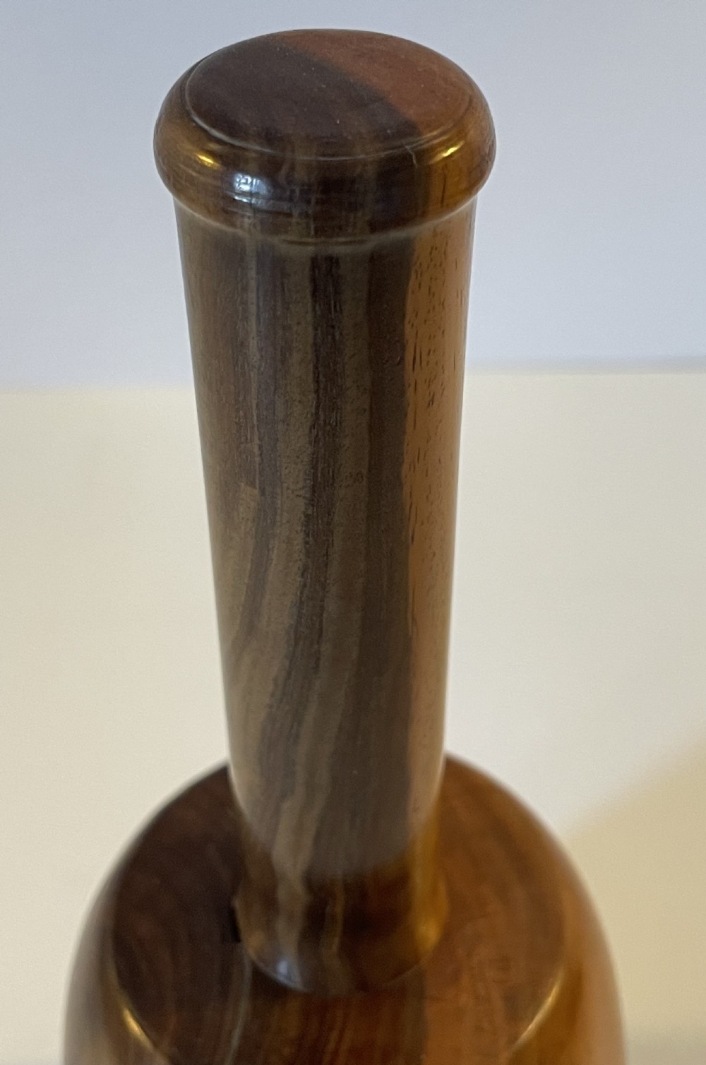 A 19th-century turned lignum vitae mallet featuring a rounded head and cylindrical handle with distinctive contrasting dark brown and light tan wood grain. View IX