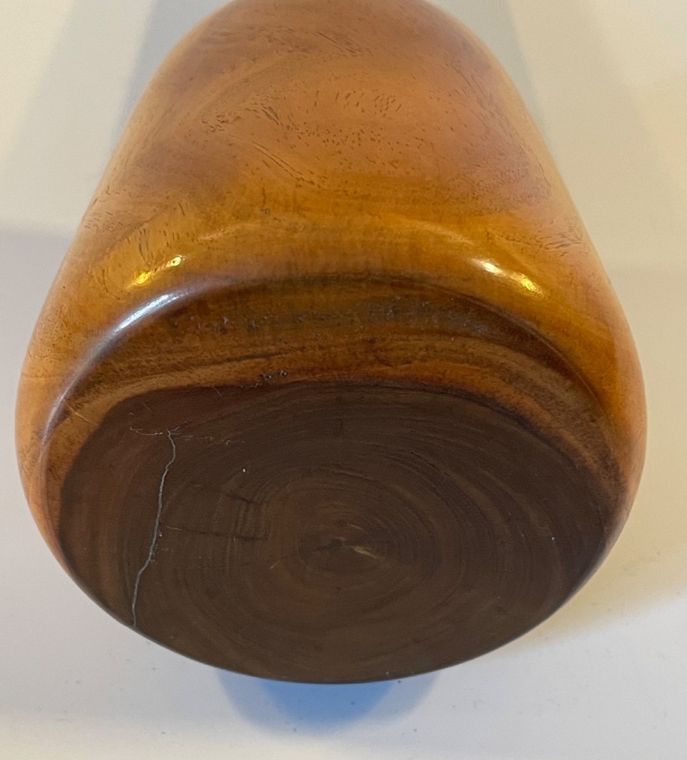 A 19th-century turned lignum vitae mallet featuring a rounded head and cylindrical handle with distinctive contrasting dark brown and light tan wood grain. View XI