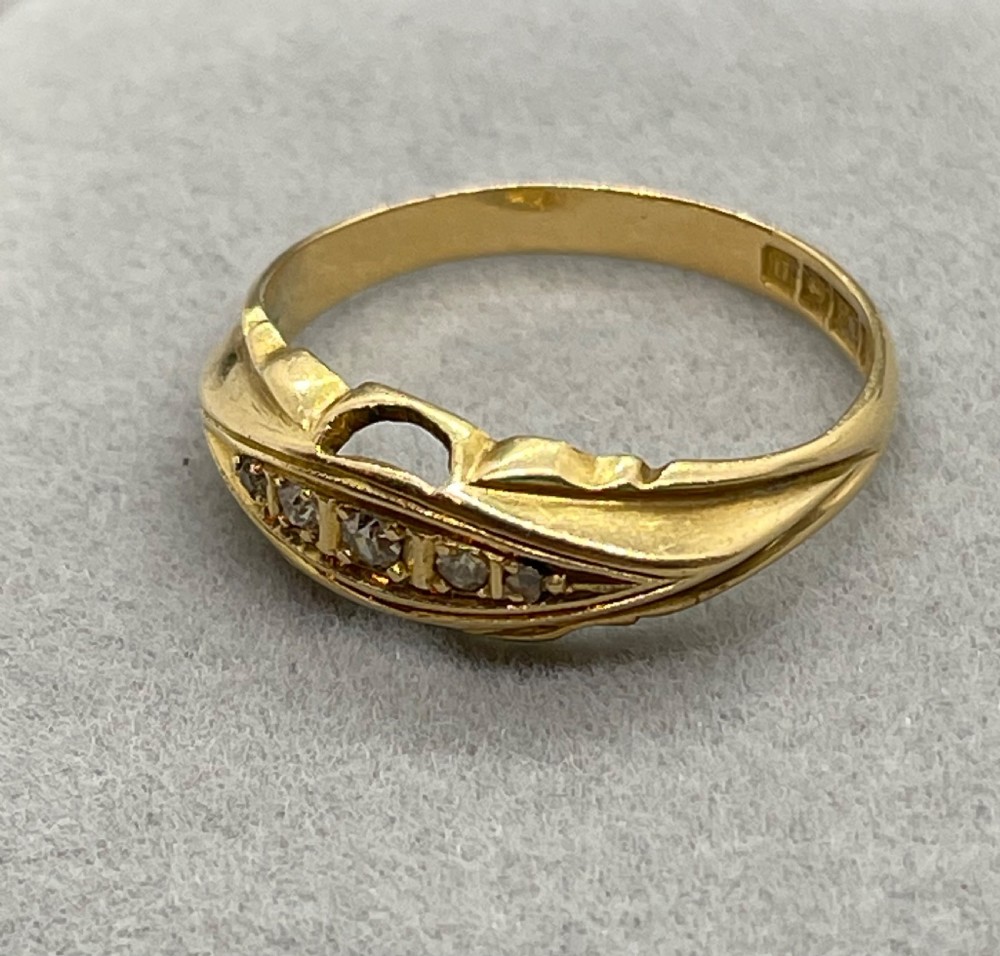 An antique 18ct yellow gold ring featuring a row of inset diamonds set within a carved boat-shaped head. View V