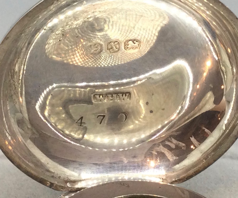 A circular Victorian sterling silver sovereign case featuring hand-engraved foliate motifs, a central monogram cartouche, and a top suspension ring. View VI