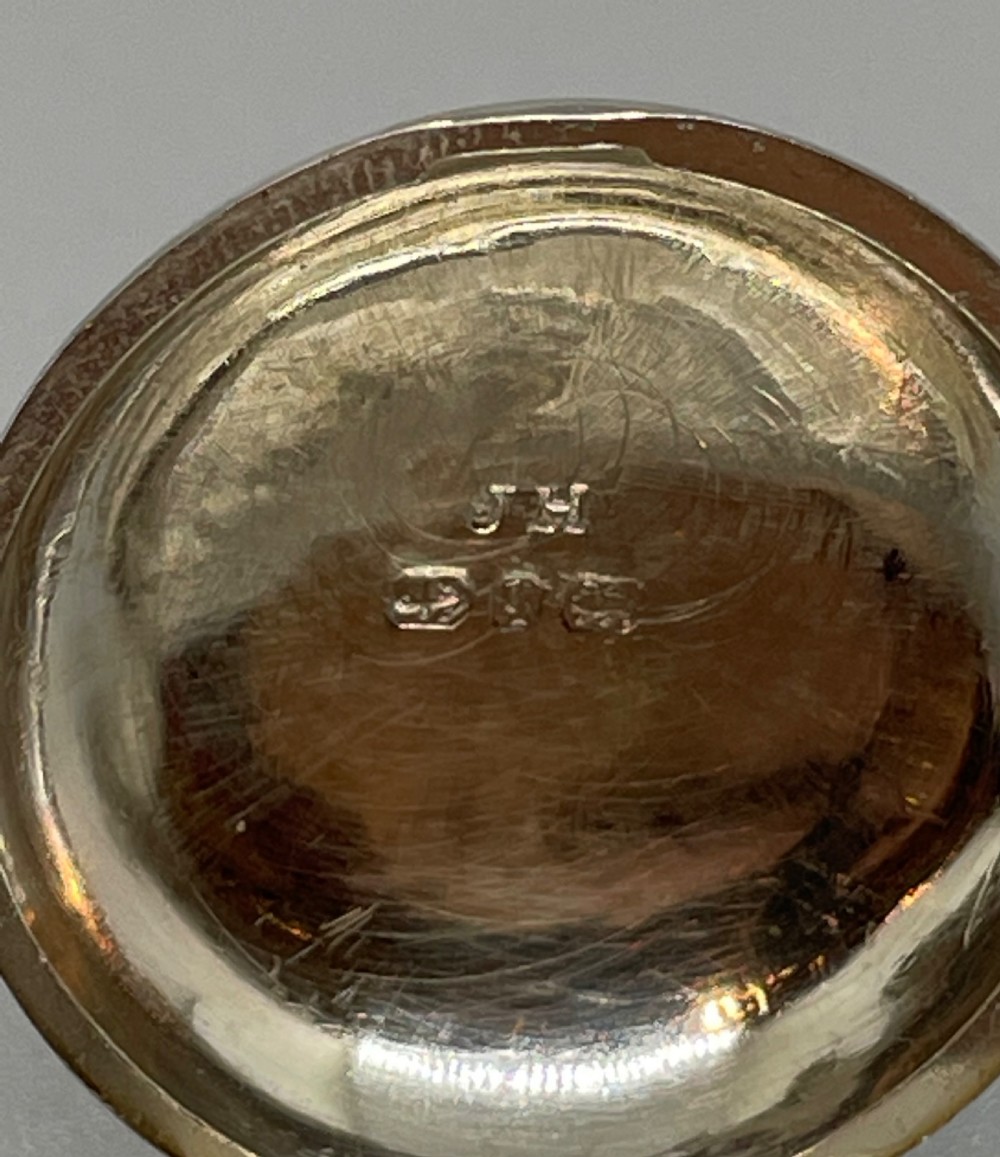 A circular Georgian sterling silver salver featuring a shaped gadrooned rim, an engraved central monogram, and three cast feet. View XII