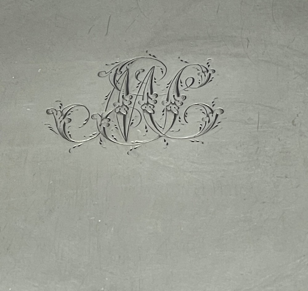 A circular Georgian sterling silver salver featuring a shaped gadrooned rim, an engraved central monogram, and three cast feet. View XVIII