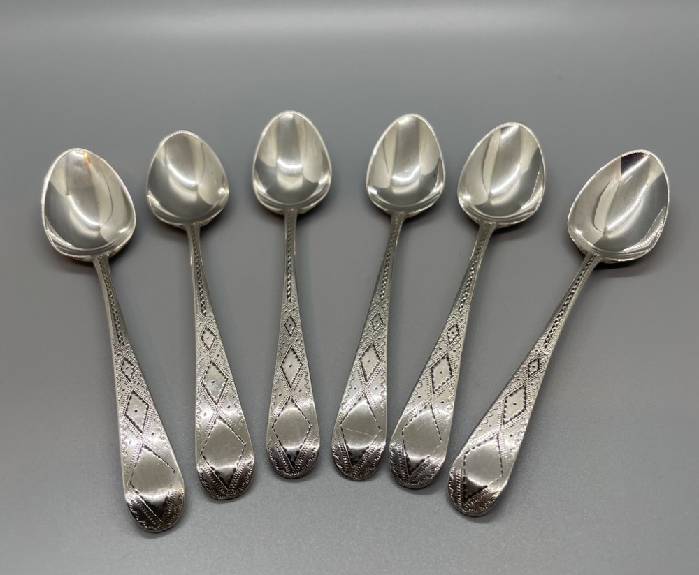 A set of six 18th-century George III sterling silver teaspoons with bright-cut lattice engraving along the handles. View II