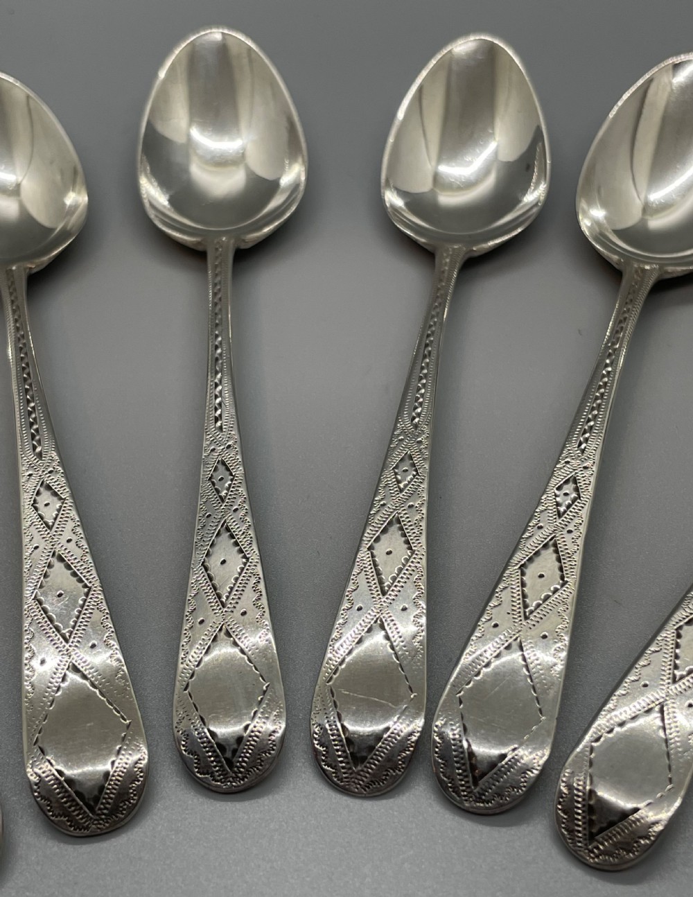 A set of six 18th-century George III sterling silver teaspoons with bright-cut lattice engraving along the handles. View III