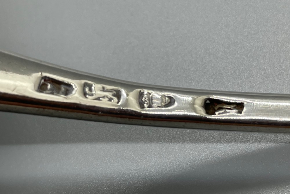 An 18th-century sterling silver soup ladle featuring a fluted shell-shaped bowl and an engraved curved handle terminal. View V