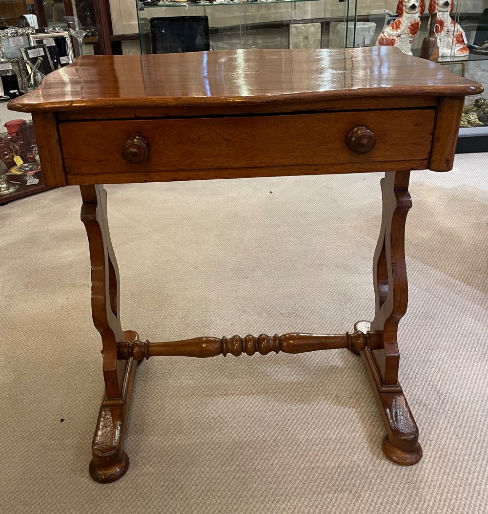 A 19th-century Victorian mahogany occasional table featuring a single drawer with wooden knobs, shaped trestle legs, and a turned stretcher.