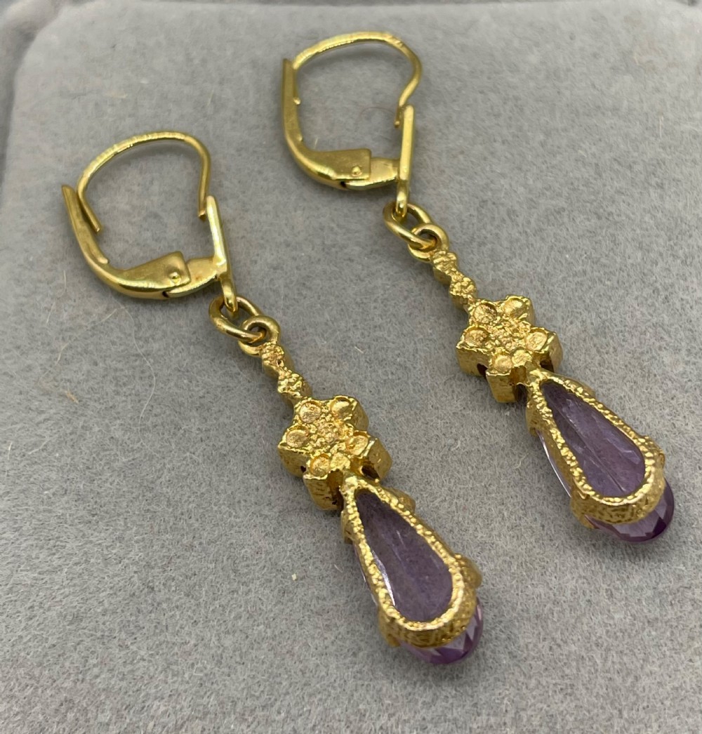 A pair of 1960s 9ct gold drop earrings featuring lever-back fastenings, textured geometric links, and pear-cut purple amethyst stones in claw settings. View III