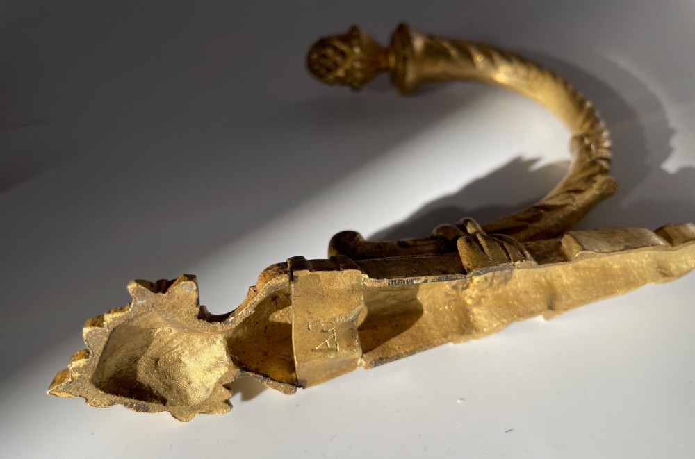 A set of four 19th-century French ormolu curtain tie backs with pinecone finials, fluted arms, and wall-mount backplates. View IX