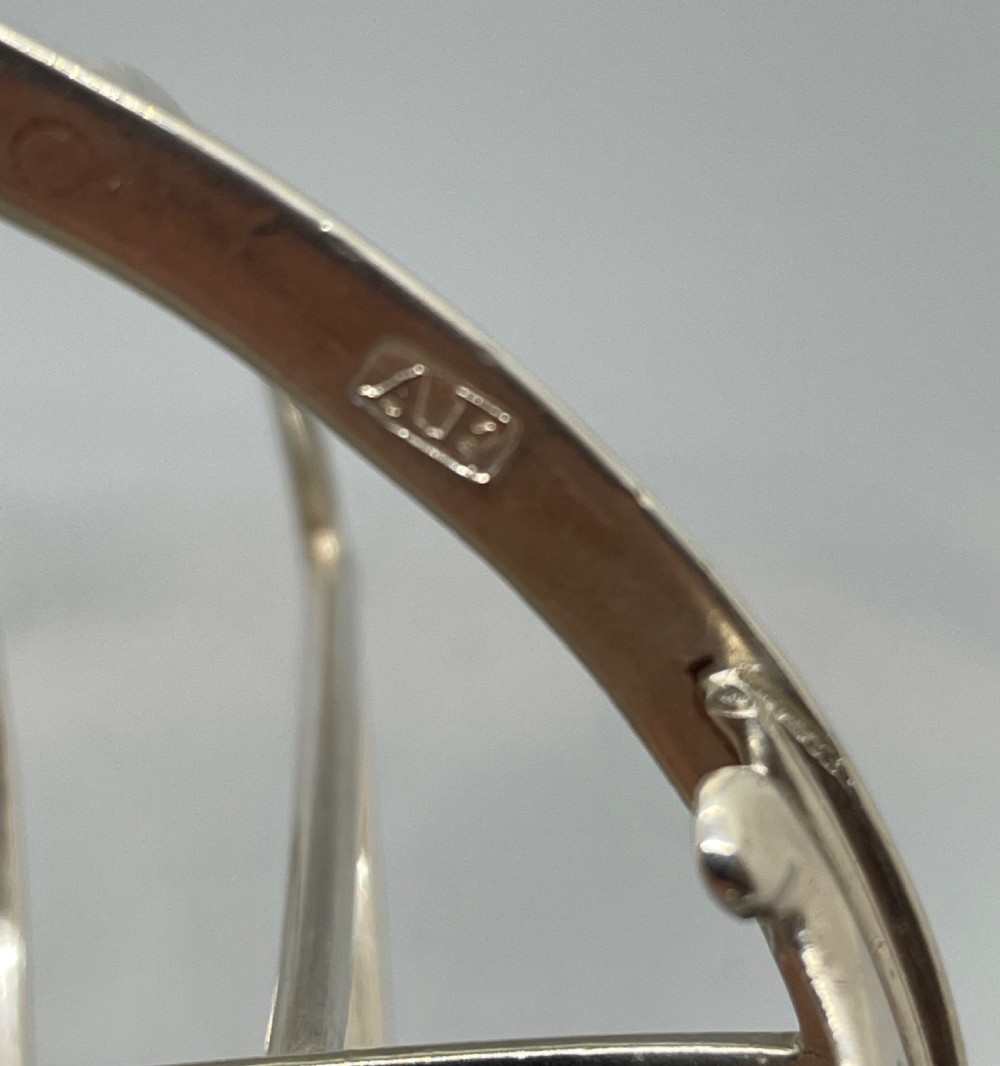 A George III sterling silver toast rack featuring seven arched divisions, an oval base frame, bracket feet, and a central ring handle. View VII