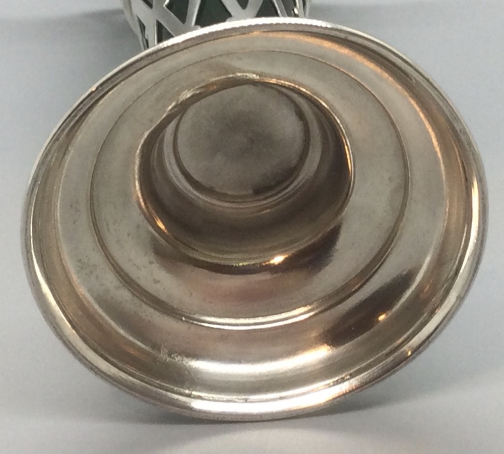 An Edwardian sterling silver vase featuring a pierced lattice body, flared scalloped rim, and a green glass liner. View IV