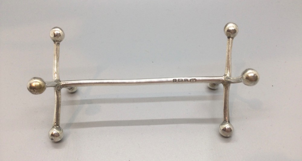 A pair of Edwardian sterling silver knife rests featuring ball-ended cross terminals joined by horizontal bars. View IV