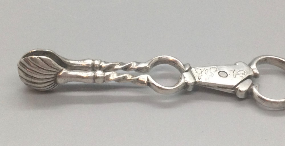 An early Georgian sterling silver scissor-style sugar nip featuring shell-shaped grips and scrolled arms with finger loops. View II