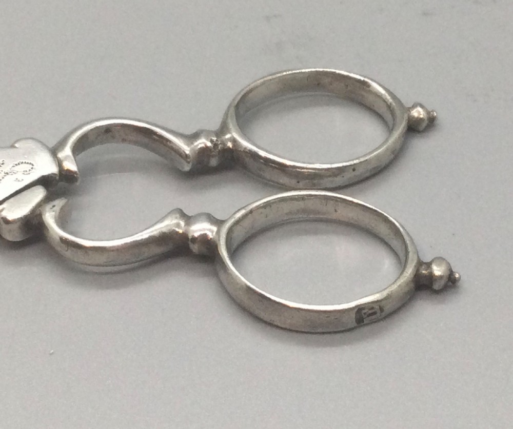 An early Georgian sterling silver scissor-style sugar nip featuring shell-shaped grips and scrolled arms with finger loops. View III