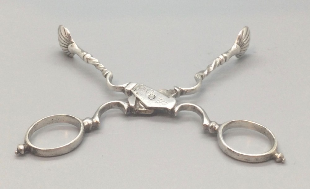 An early Georgian sterling silver scissor-style sugar nip featuring shell-shaped grips and scrolled arms with finger loops. View V