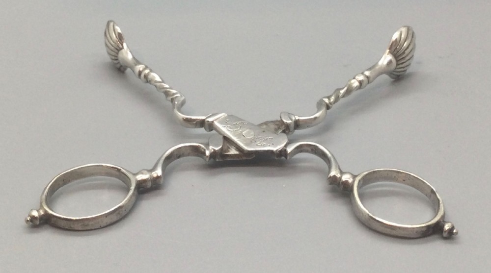 An early Georgian sterling silver scissor-style sugar nip featuring shell-shaped grips and scrolled arms with finger loops. View VI