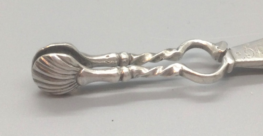 An early Georgian sterling silver scissor-style sugar nip featuring shell-shaped grips and scrolled arms with finger loops. View VII
