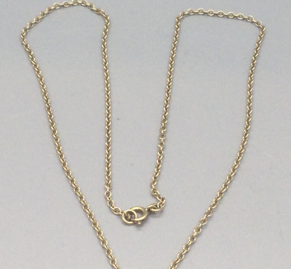 A vintage 9ct yellow gold chain necklace supporting a circular floral pendant set with a central round dark red garnet and surrounding white seed pearls. View VI