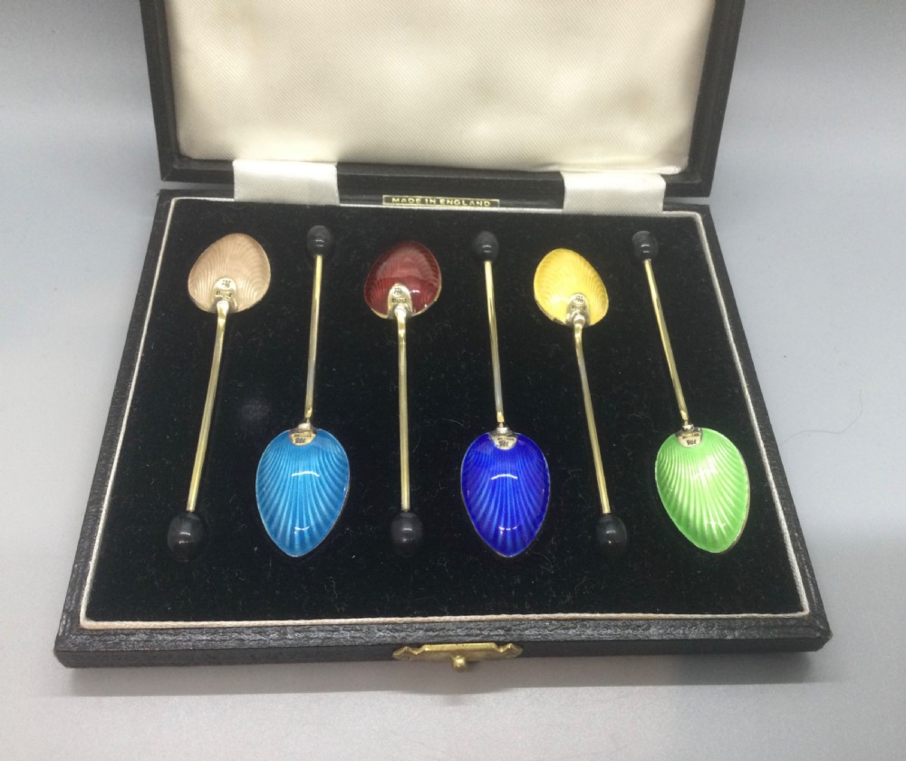 A set of six Art Deco silver gilt coffee spoons featuring colourful guilloche enamel backs, presented in a black velvet-lined case. View II
