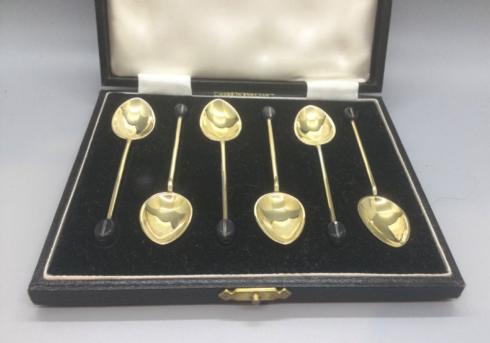 A set of six Art Deco silver gilt coffee spoons featuring colourful guilloche enamel backs, presented in a black velvet-lined case. View III