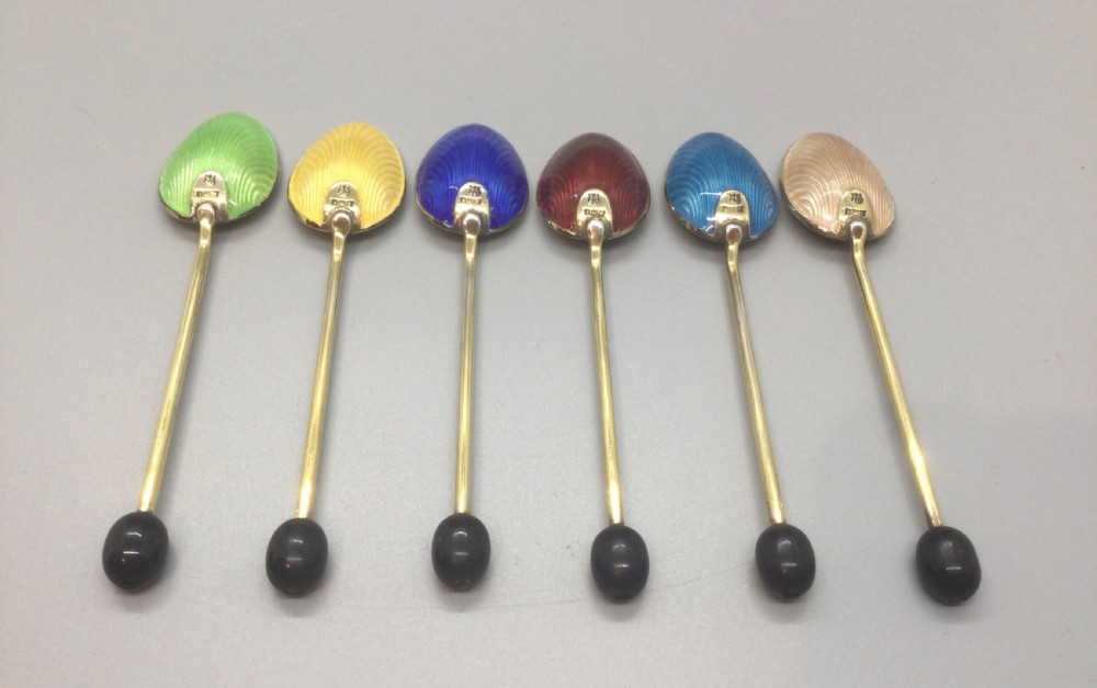 A set of six Art Deco silver gilt coffee spoons featuring colourful guilloche enamel backs, presented in a black velvet-lined case. View IV