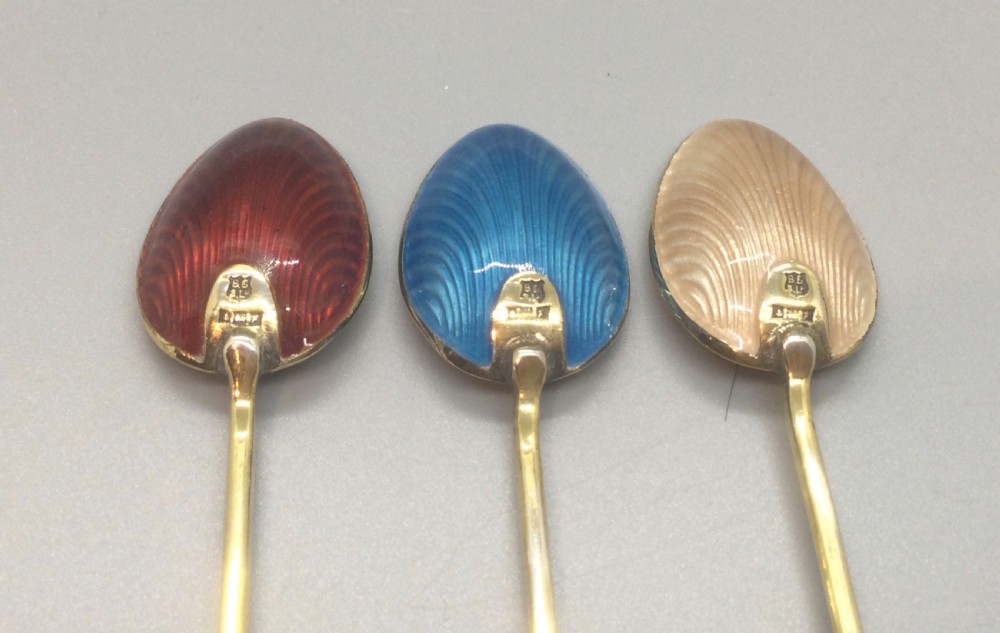 A set of six Art Deco silver gilt coffee spoons featuring colourful guilloche enamel backs, presented in a black velvet-lined case. View V