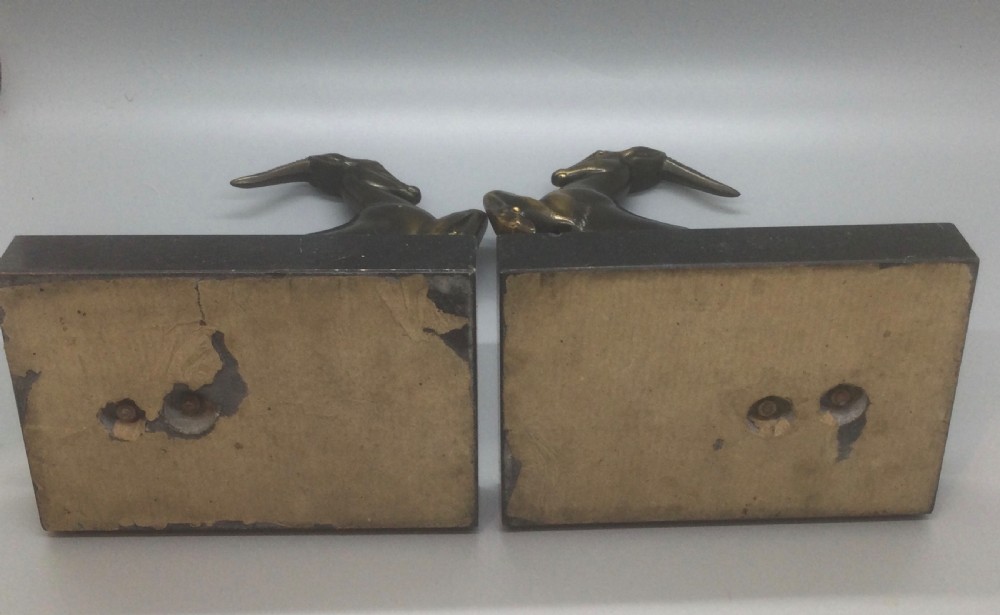 A pair of French Art Deco spelter bookends featuring leaping gazelles mounted on dark rectangular marble bases. View IX
