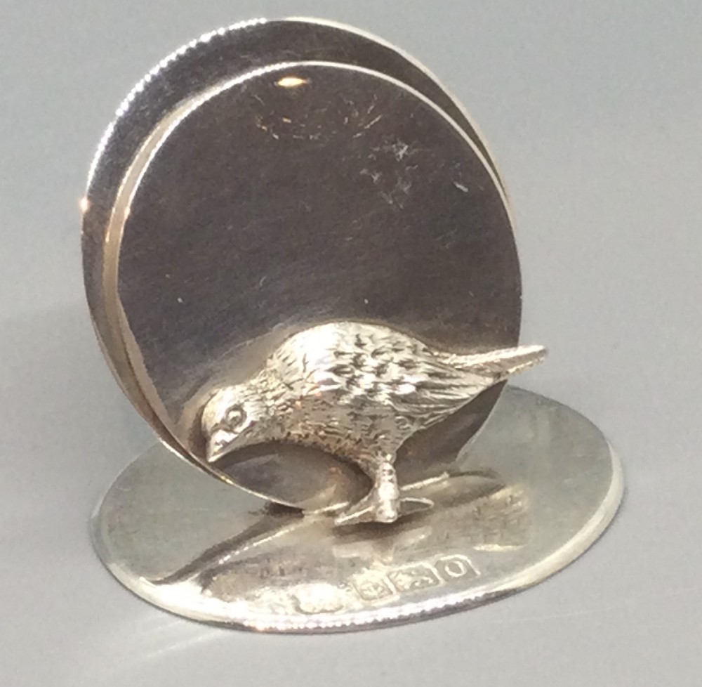 A pair of Edwardian sterling silver circular menu holders featuring sculpted game birds mounted on oval silver bases. View V