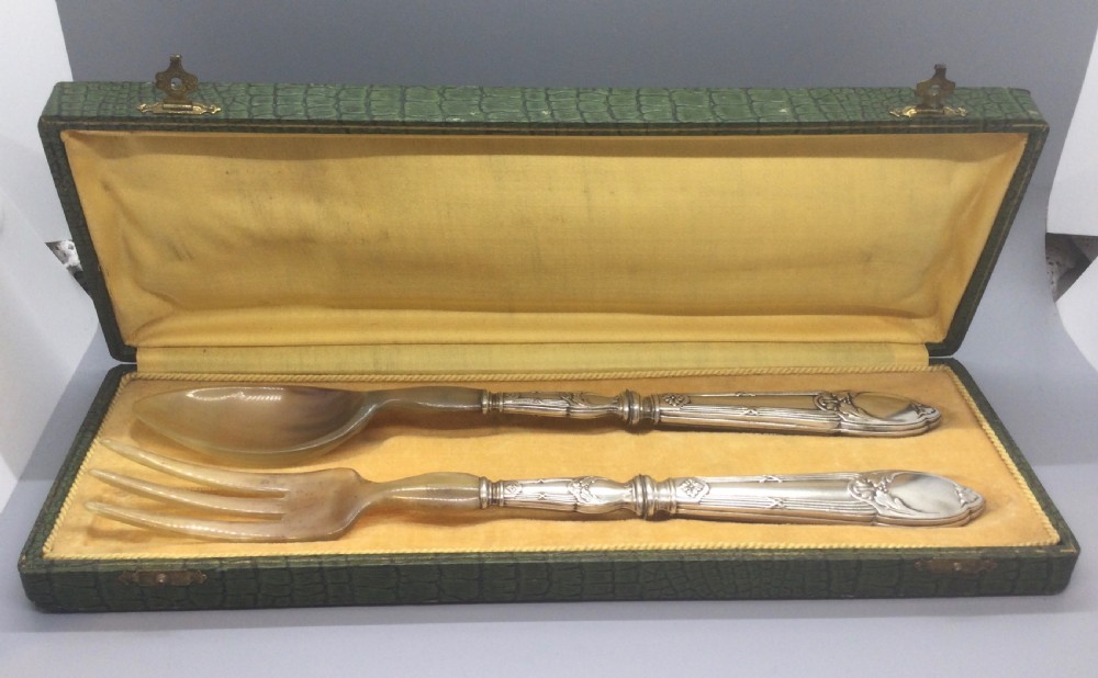 A late nineteenth-century French silver and horn salad serving set presented inside an open green fitted box with yellow lining.