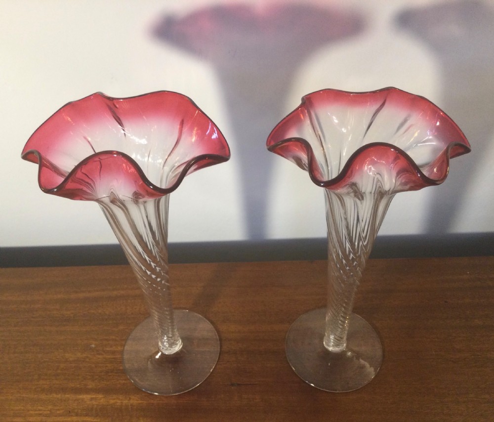 A pair of tall Art Nouveau glass trumpet vases featuring flared, ruffled cranberry rims and clear spiral-twisted stems on round bases. View III