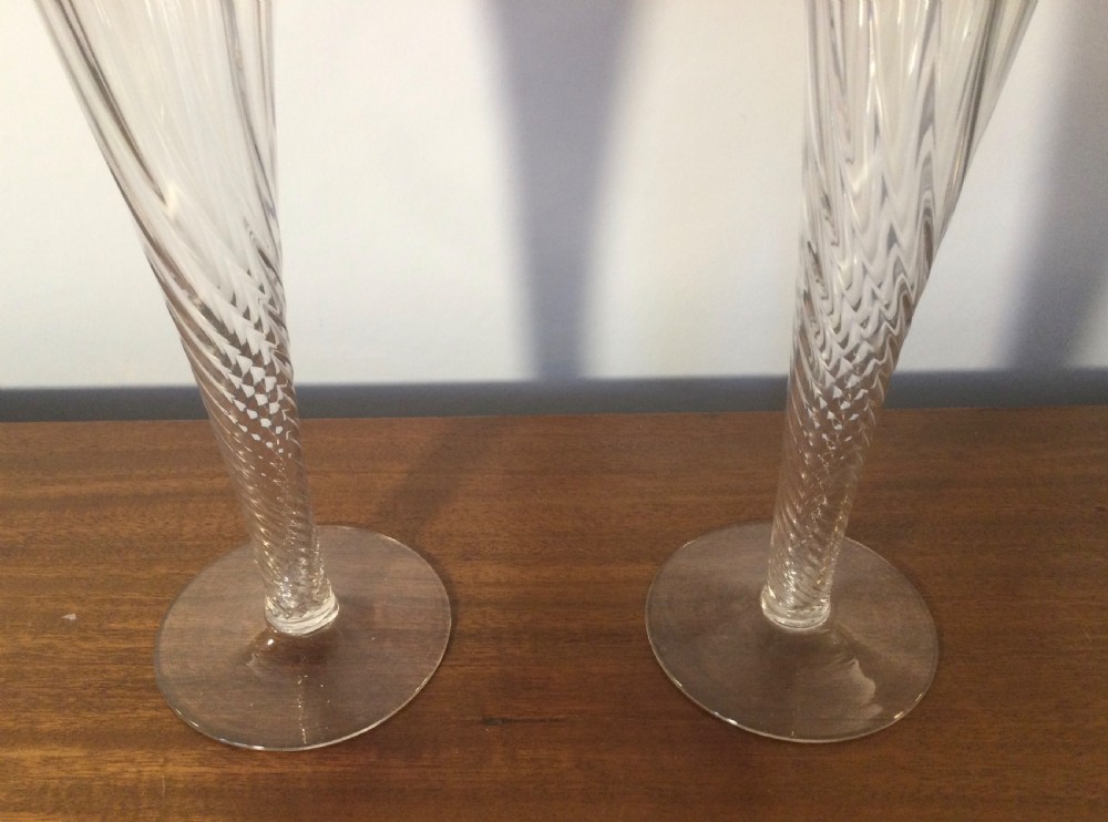 A pair of tall Art Nouveau glass trumpet vases featuring flared, ruffled cranberry rims and clear spiral-twisted stems on round bases. View VI