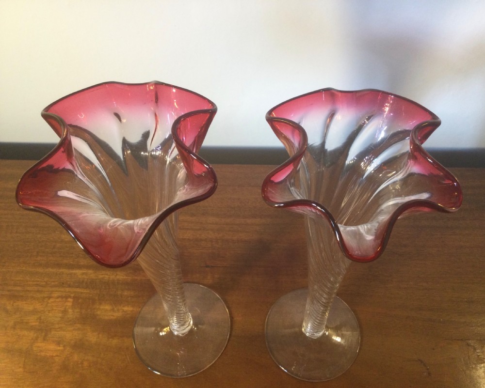A pair of tall Art Nouveau glass trumpet vases featuring flared, ruffled cranberry rims and clear spiral-twisted stems on round bases. View VIII