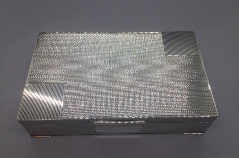 A rectangular sterling silver Art Deco box featuring an engine-turned geometric pattern and a small cartouche on the front edge. View III