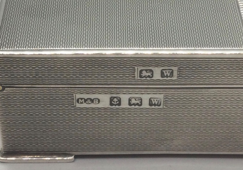 A rectangular sterling silver Art Deco box featuring an engine-turned geometric pattern and a small cartouche on the front edge. View VII
