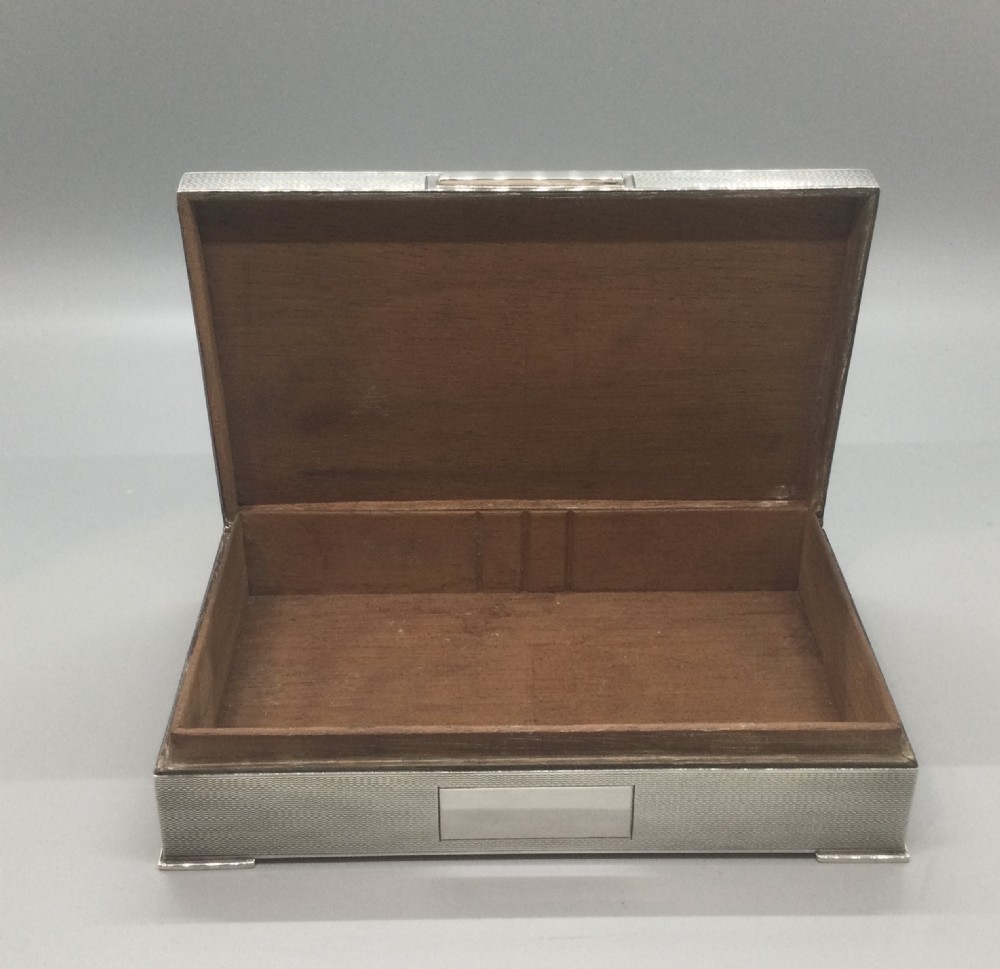 A rectangular sterling silver Art Deco box featuring an engine-turned geometric pattern and a small cartouche on the front edge. View VIII