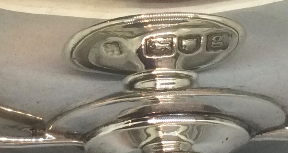 A polished sterling silver pedestal bowl featuring two curved loop handles, a wide shallow dish, and a circular turned foot. View VI