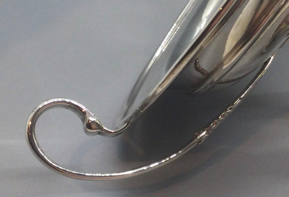 A polished sterling silver pedestal bowl featuring two curved loop handles, a wide shallow dish, and a circular turned foot. View VIII