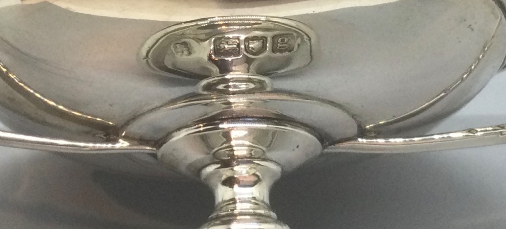 A polished sterling silver pedestal bowl featuring two curved loop handles, a wide shallow dish, and a circular turned foot. View XI