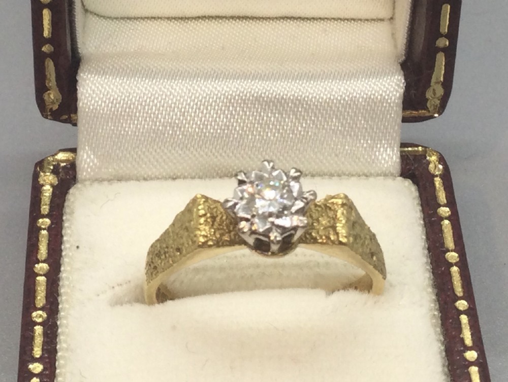 A vintage 18ct yellow gold solitaire ring featuring a textured bark-effect band and a central diamond in a claw setting.